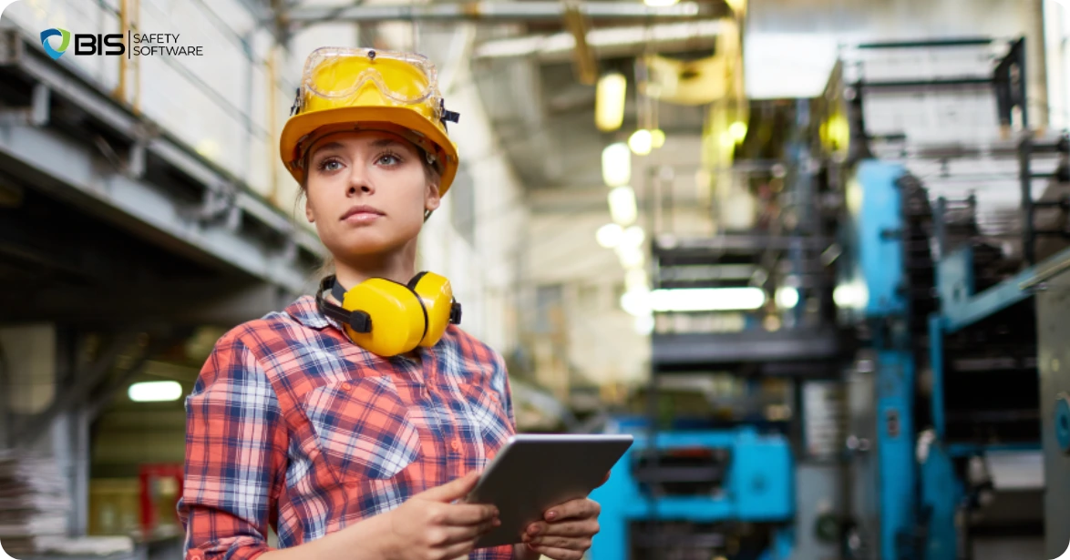 Female engineer inspecting machinery in a factory.
