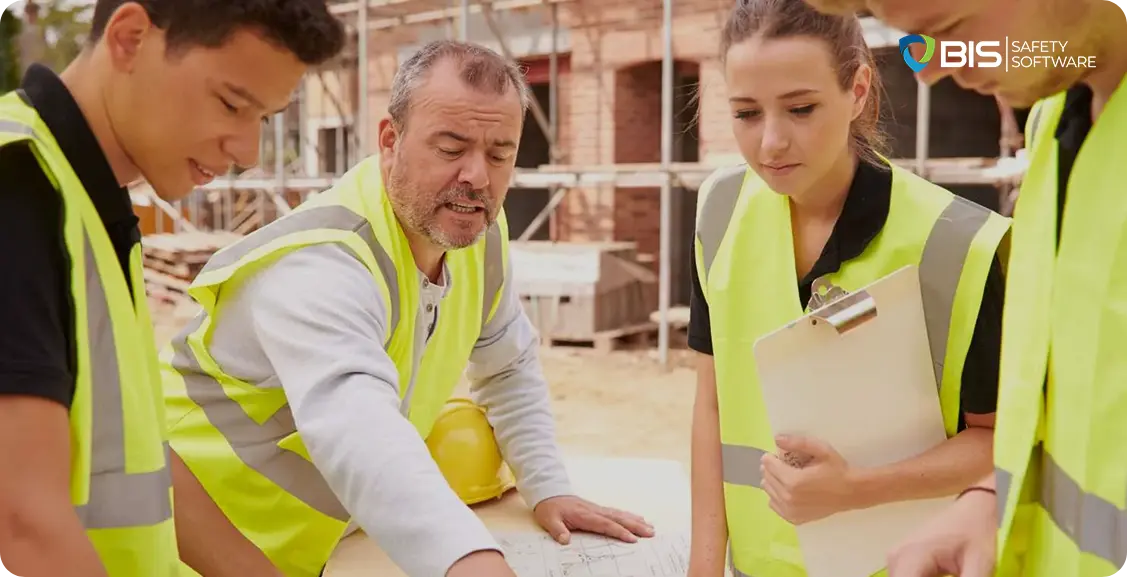 Construction team wearing safety vests reviews blueprints at a building site.