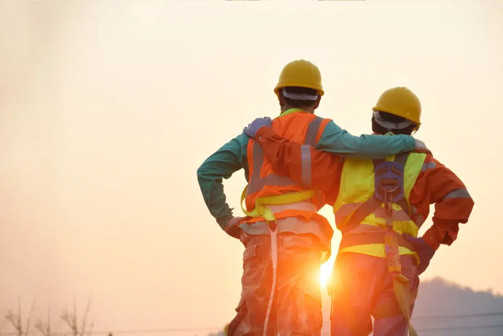 Construction workers in safety gear, highlighting unity and workplace safety.
