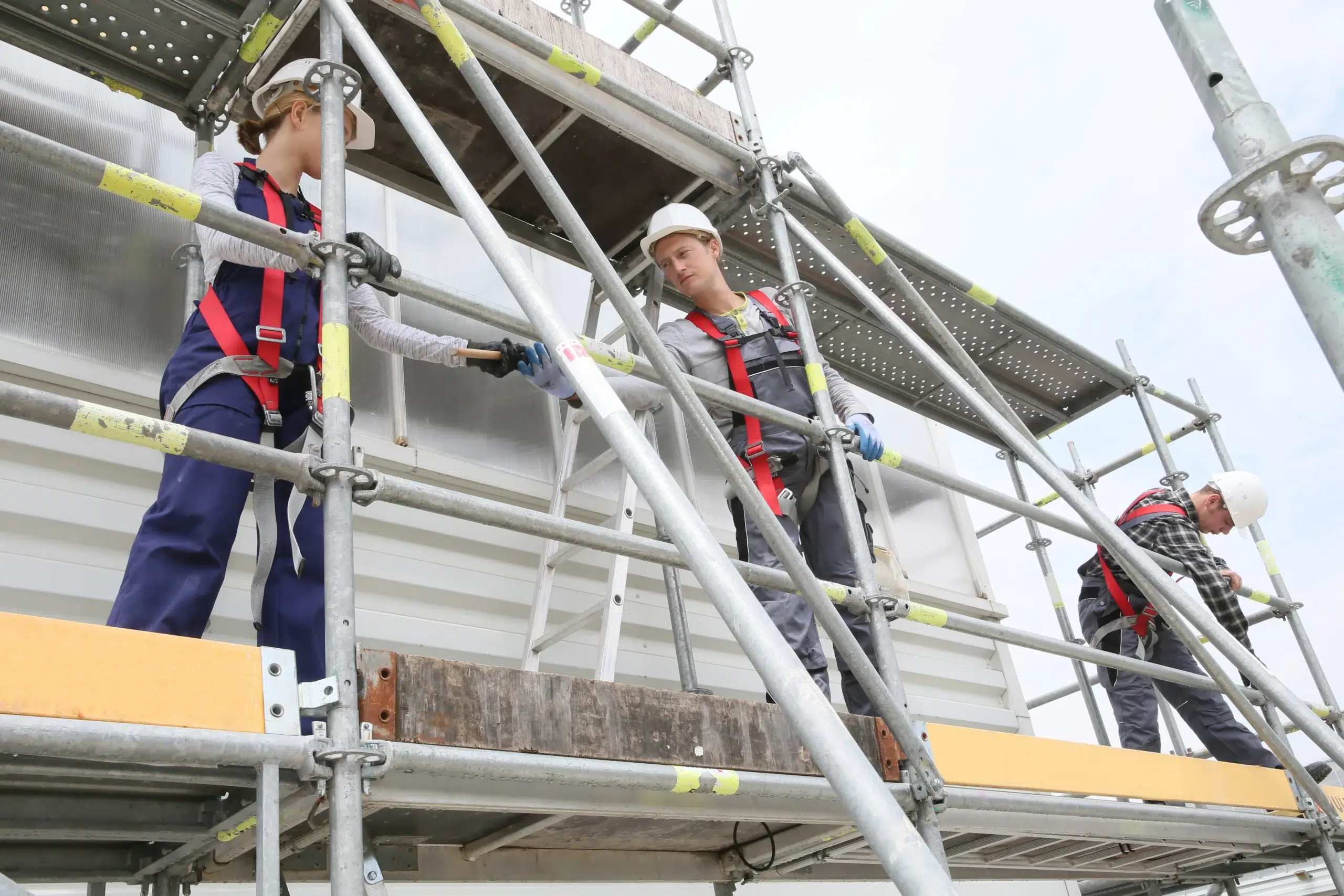 Canadian crew on scaffolding using fall protection equipment safely.