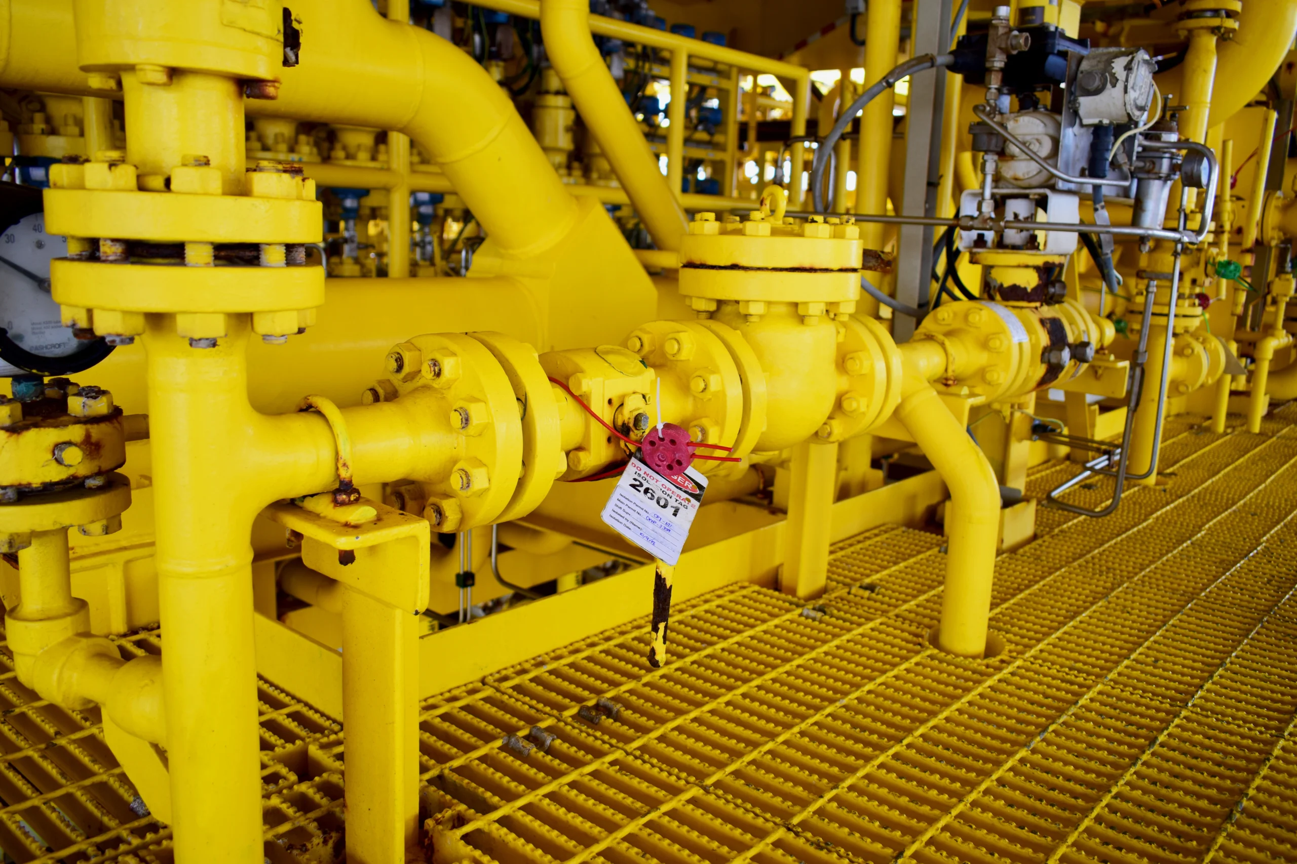 Technician applying lockout tag on industrial valve to control hazardous energy.