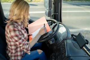 Female driver recording duty hours and off-duty time to comply with Canadian HOS regulations.