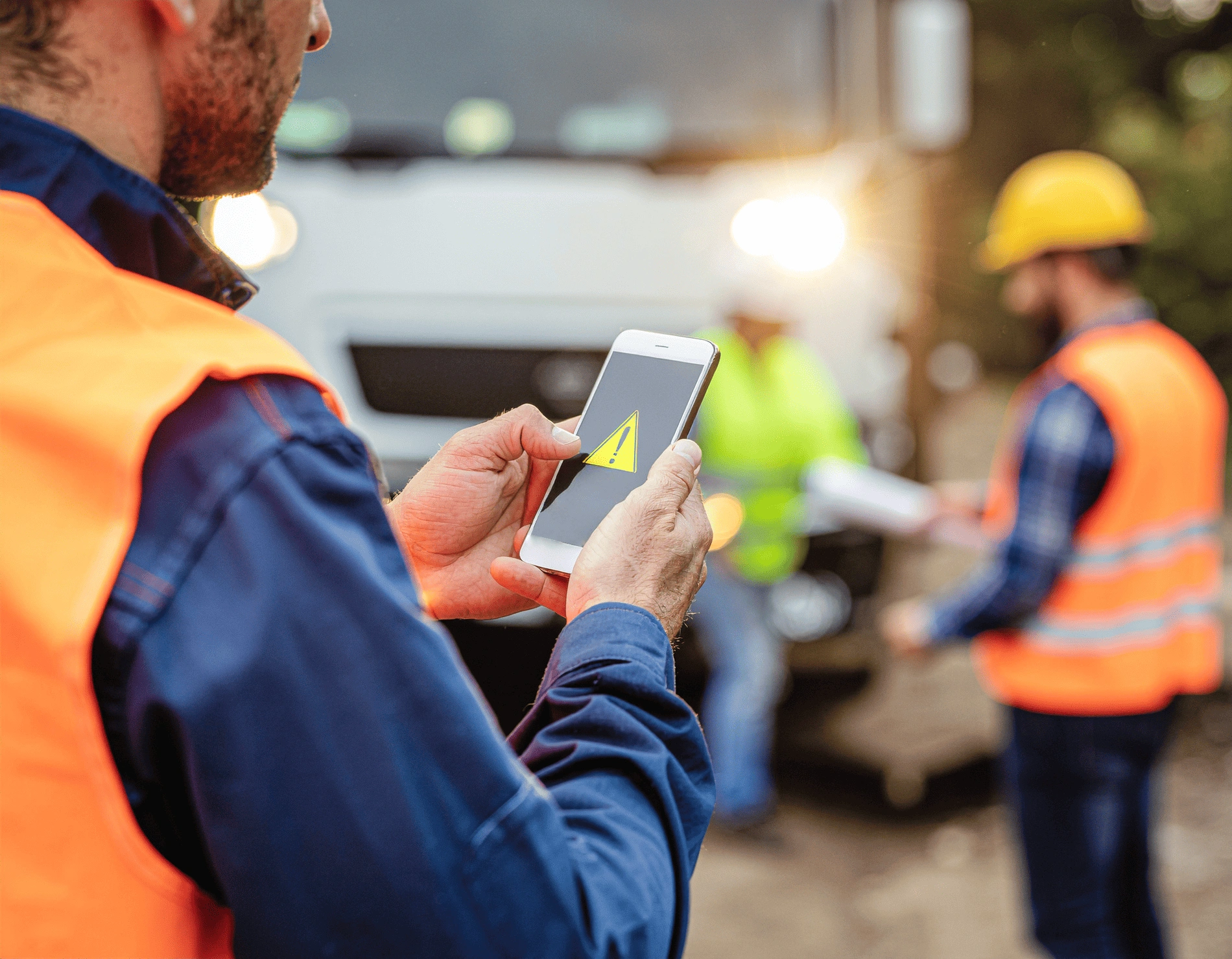 Site supervisor in PPE completing a digital safety inspection on a tablet.