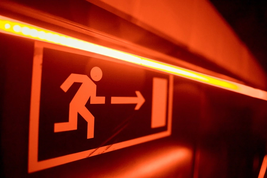 Fire exit sign used to guide people in a state of emergency. Fire Exits should be among the primary workplace safety topics for meetings.