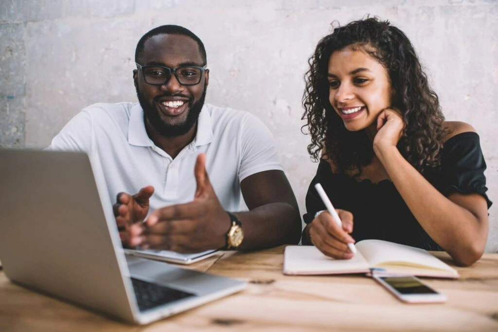 - BIS Safety Software Canada Cheerful african american male and female colleagues discussing project ideas making research on laptop computer, smiling dark skinned man explaining information to female student via webinar