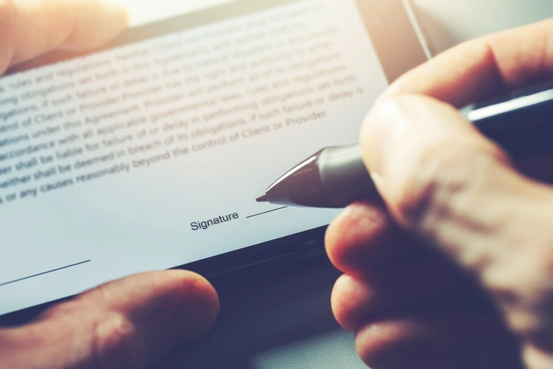 A person uses a stylist to sign a digital form